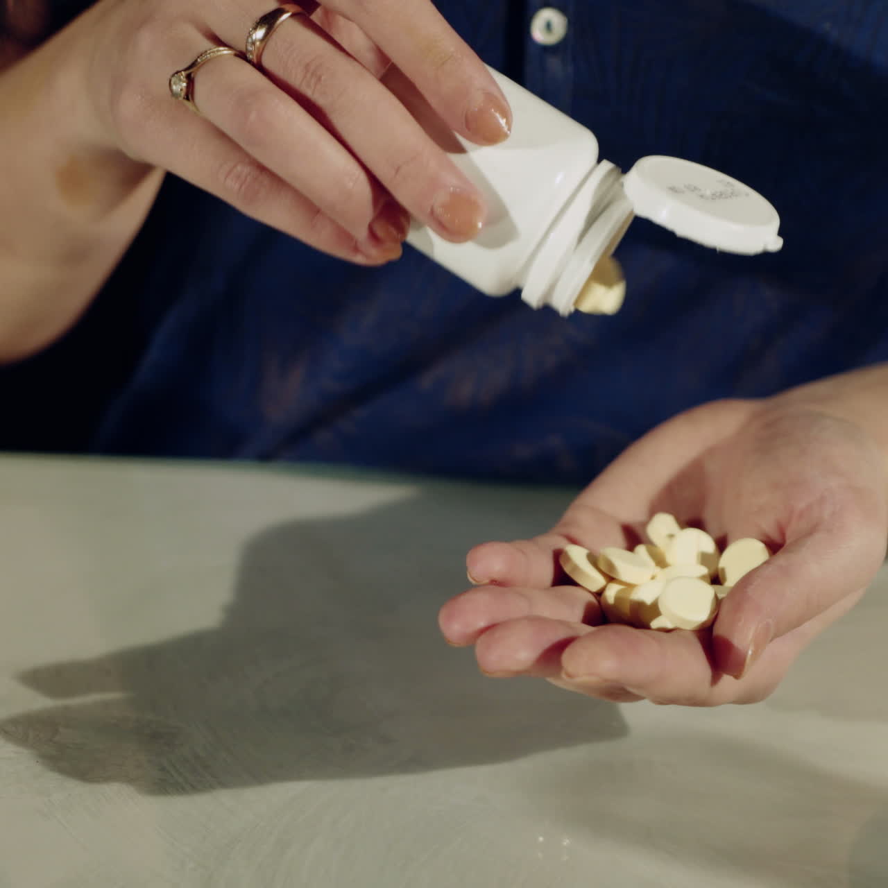 One step from death. Close up of pills in hands of young depressed girl holding them and going to take