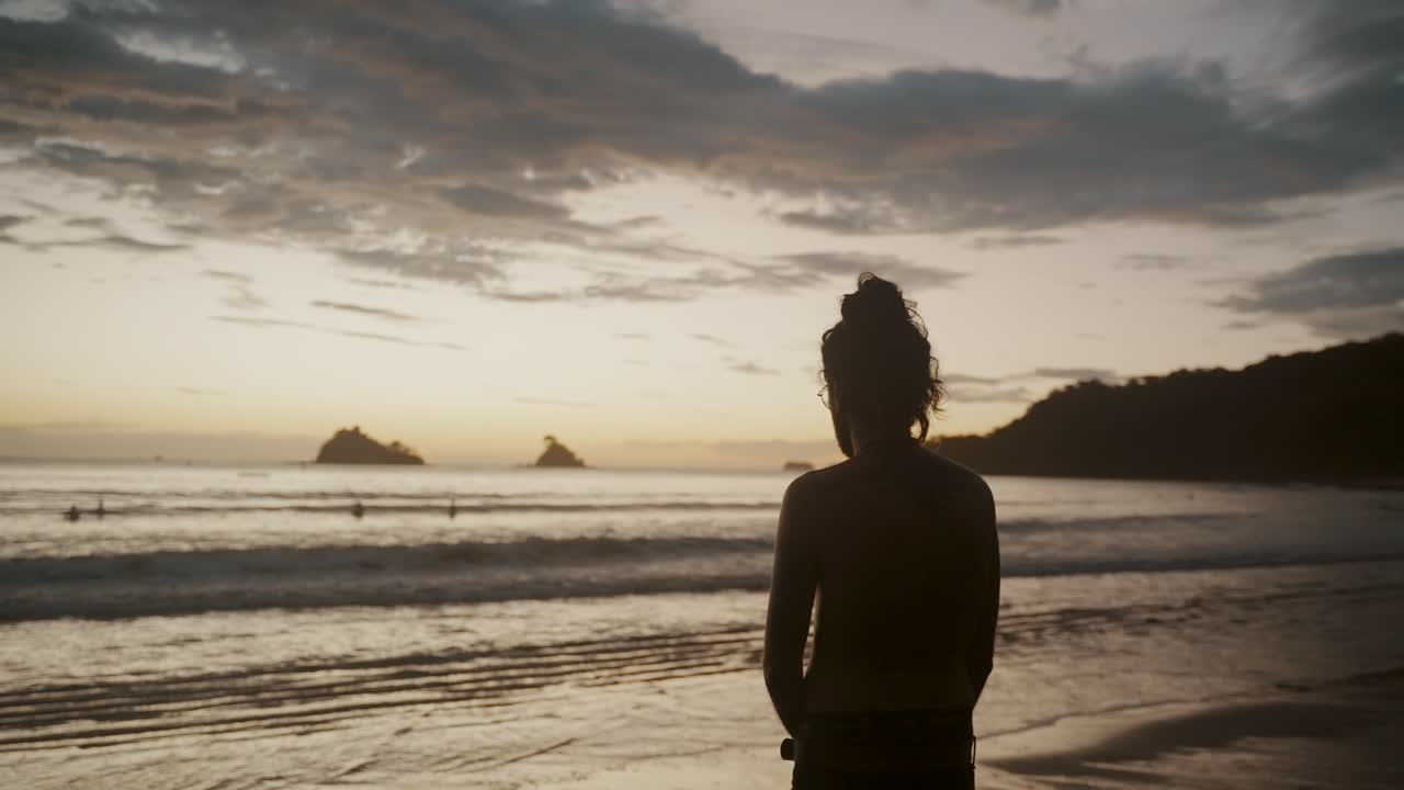 Lone Man In Front Of A Tropical Beach Pondering During Sunset