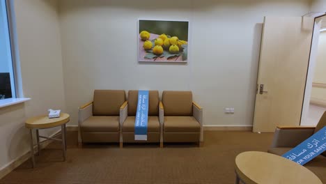 Arabic-"for-your-safety-leave-space"-signs-cover-seats-in-a-medical-waiting-room-due-to-COVID-19