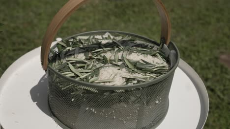 basket filled with rice and olive leaves, prepared for a traditional wedding toss