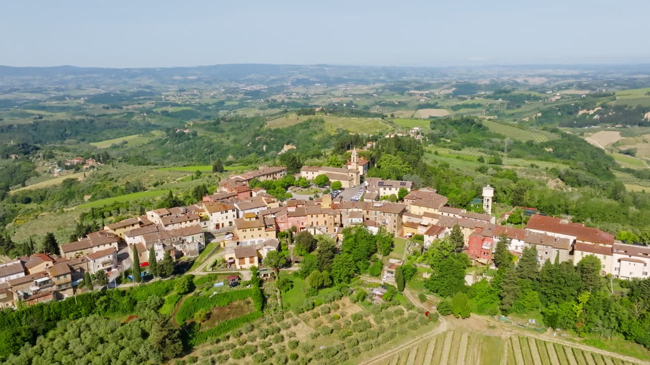 Panoramic drone shot circling the Marcialla town, summer day in Tuscany, Italy