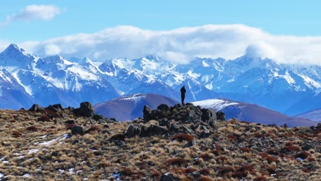 Traveler-enjoying-beautiful-winter-mountain-landscape-of-snowy-peaks