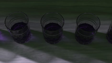 purple drinks in shot glasses on a table