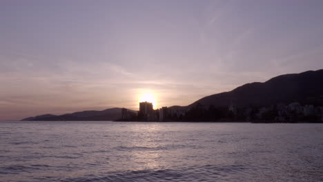 la puesta de sol sobre las hermosas olas y la costa del norte de vancouver - amplia