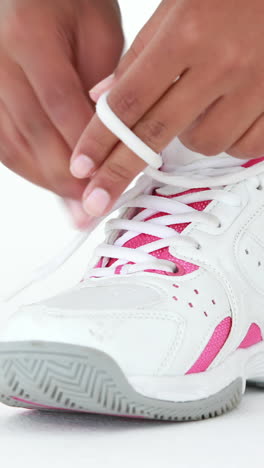 corredora atlética atando los cordones de sus zapatos