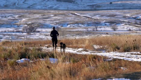 Man-running-on-a-dirt-trail-with-his-dog