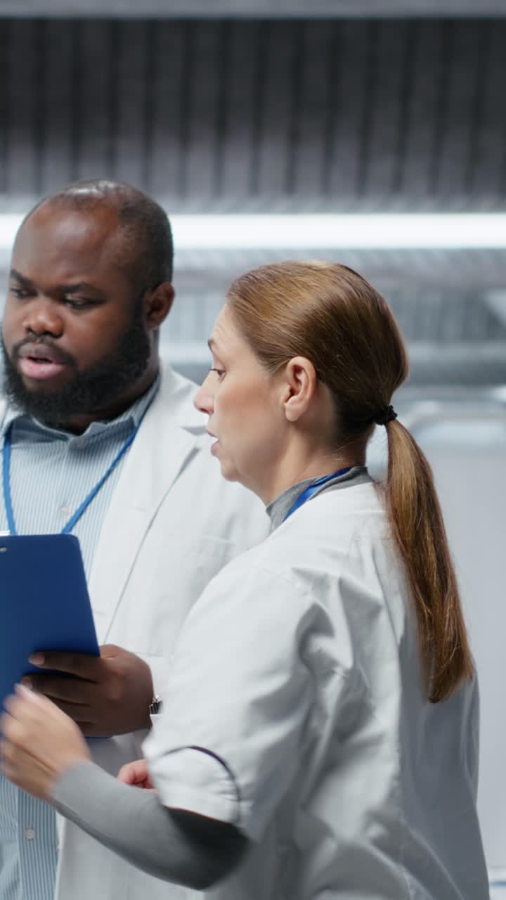 Vertical Video Doctors in a clinical research procedure examining DNA results on monitor