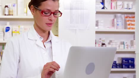 pharmacist using laptop in pharmacy