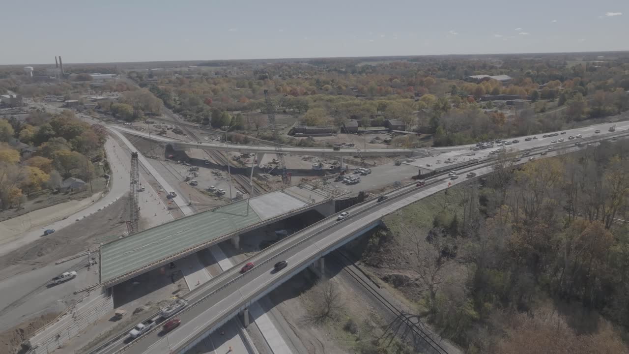 US 127 Trowbridge exit bridge and freeway construction with traffic driving and drone video moving in a circle.