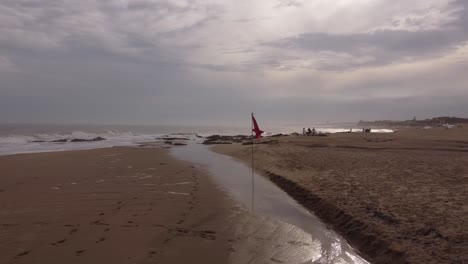 Red-Flag-Waving-In-Strong-Wind-At-Cloudy-Day-In-Famous-Punta-Del-Este-Beach