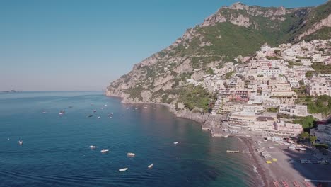 aerial drone shot crane up looking at buildings and beach in positano, italy