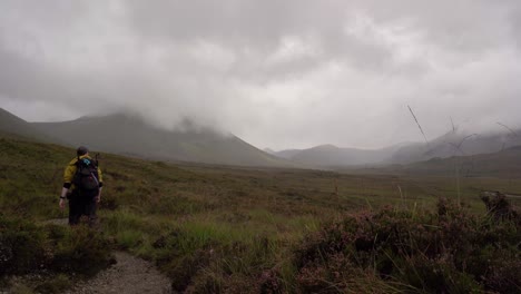 hiking walking down a mountain trail through the scottish mountains