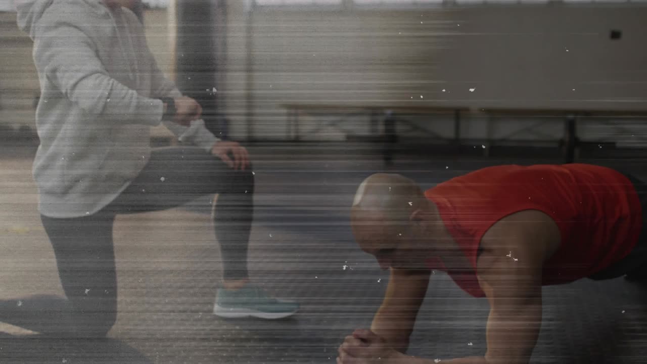 Trainer tapping wrist device and timing client holding forearm plank for fitness goal