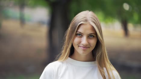 Hermosa-Joven-Rubia-Posando-Con-El-Telón-De-Fondo-De-Un-Ambiente-Tranquilo-En-El-Parque.-Paseo-Por-El-Parque,-Picnic.-Felicidad