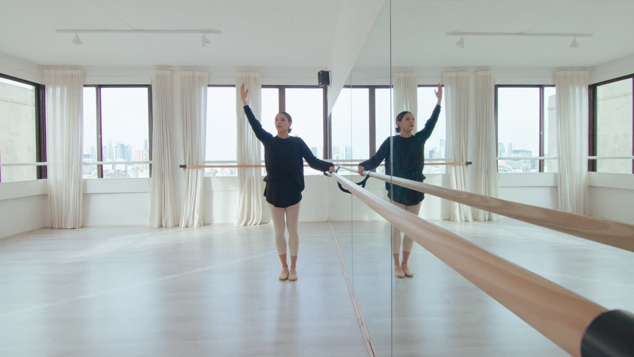 Ballerina Doing Side Stretch at the Barre in Dance Studio