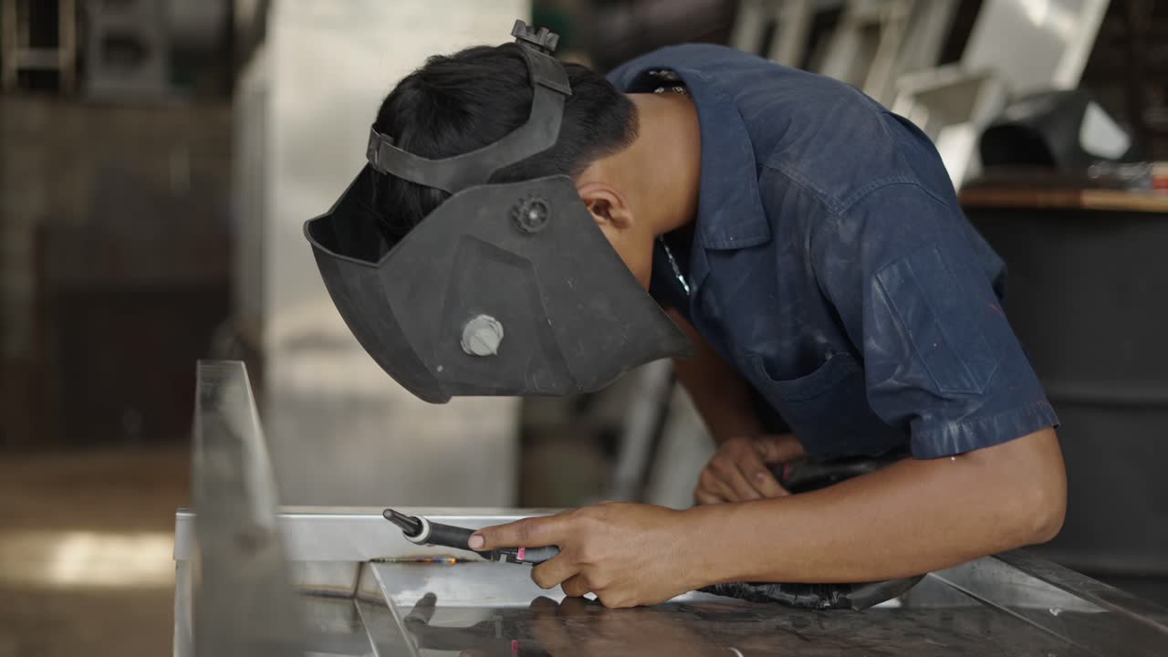 hombre soldando metal en un taller