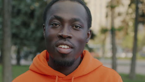 portrait of a man wearing an orange hoodie