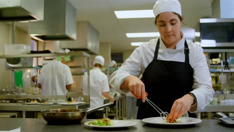 chef mujer organizando la comida en el plato 4k