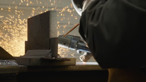 man welding metal frame with a lot of sparkles flying by slow motion