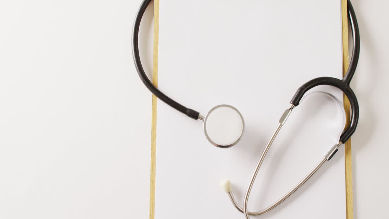 vidéo du stéthoscope avec du papier blanc vierge sur le presse-papiers, sur fond blanc avec un espace de copie