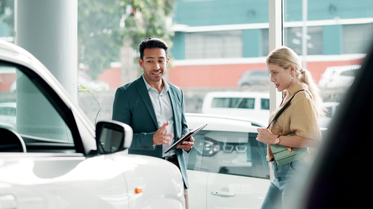 Customer talking to salesman at car dealership