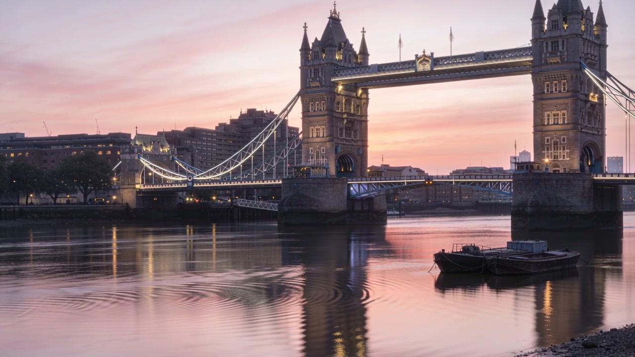 Enquadrando a Tower Bridge brilhando no Rio Tâmisa ao pôr do sol, com ondulações se expandindo da esquerda da barcaça.
