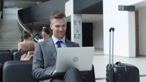 businessman using laptop while waiting in airport