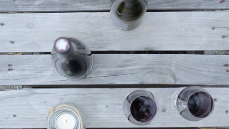 botellas de vino y vasos disparados por encima de la cabeza en exhibición en una mesa
