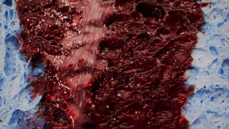 red glitter paint on blue sponge