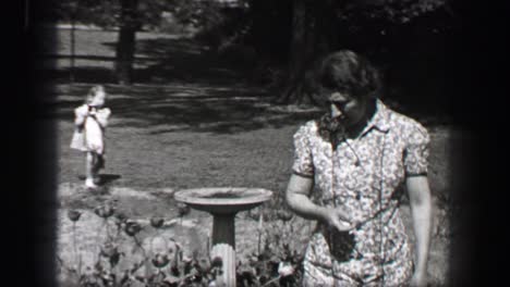 1939: mother calling young girls in white formal sundress to come inside for supper.