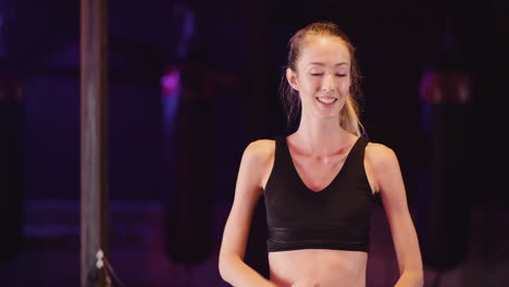 Portrait-Of-Attractive-Slim-Young-Woman-Cheering-With-Clenched-Fists-At-Fitness-Studio