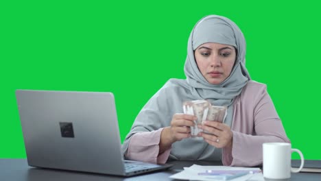 Serious-Muslim-businesswoman-counting-money-Green-screen