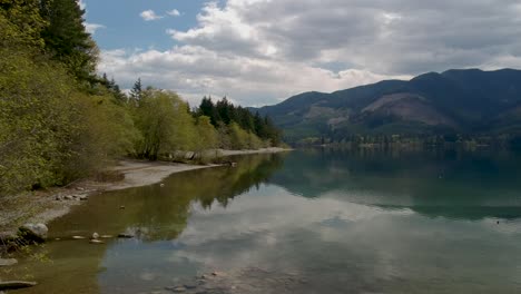 Toma-De-Drone-De-Lago-Y-Montañas-Con-Playa