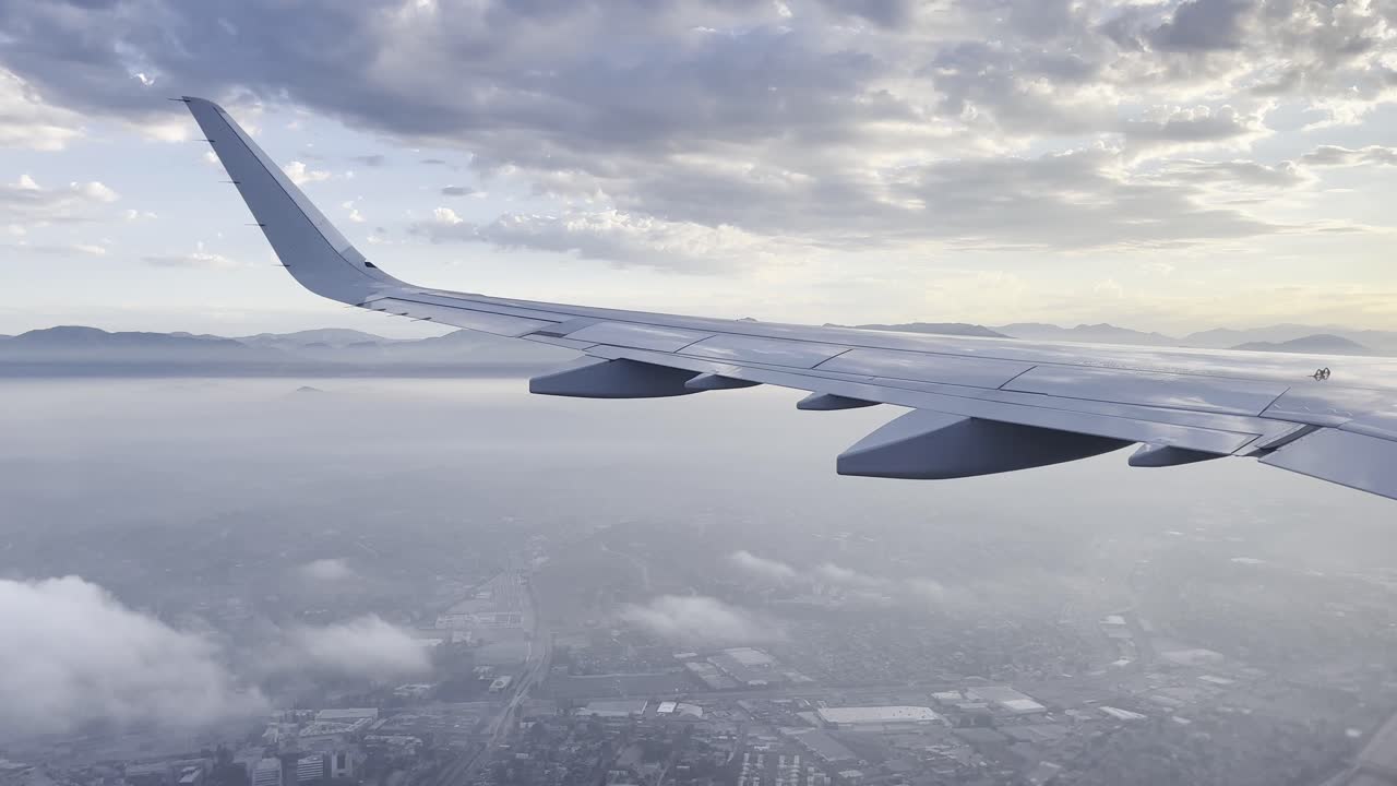 vista del avión girando mientras vuela viendo el cielo sobre las nubes a través de la ventana