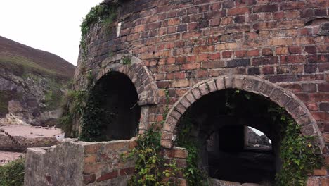 porth cubierto de maleza abandonada domo de ladrillos galés horno ruinas tire hacia atrás a través del arco
