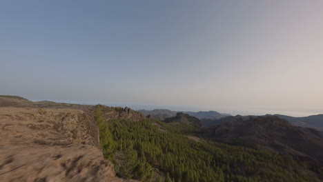 fpv drone pilot speeding across roque nublo sunset mountain valley landscape, gran canaria