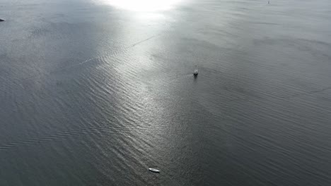 lonely sailboat at sea in the danish sunset - high angle aerial looking down at boat in aarhus denmark