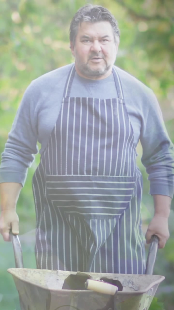 Zusammengesetztes Video von hängenden Blättern vor einem kaukasischen älteren Mann, der einen Gartenwagen im Garten bewegt.