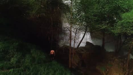 Young-male-standing-in-mountain-trail-starring-at-Kfarhelda-waterfall-,-Lebanon,-circle-shot