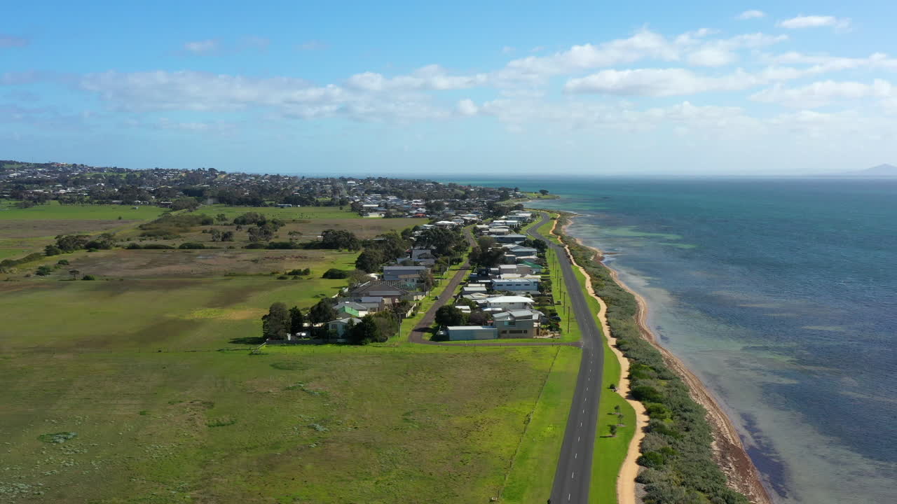 화창한 날에 푸른 들판과 집들이 있는 공중 호주 해안선