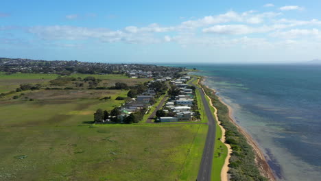 aerial australian coastline with green fields and houses on a sunny day