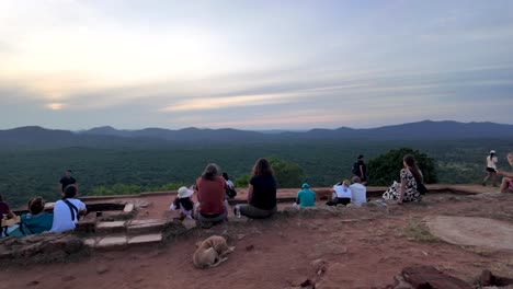 tourists eagerly await the stunning morning sunrise from the iconic sigiriya lion rock in sri lanka, offering breathtaking views of lush landscapes.