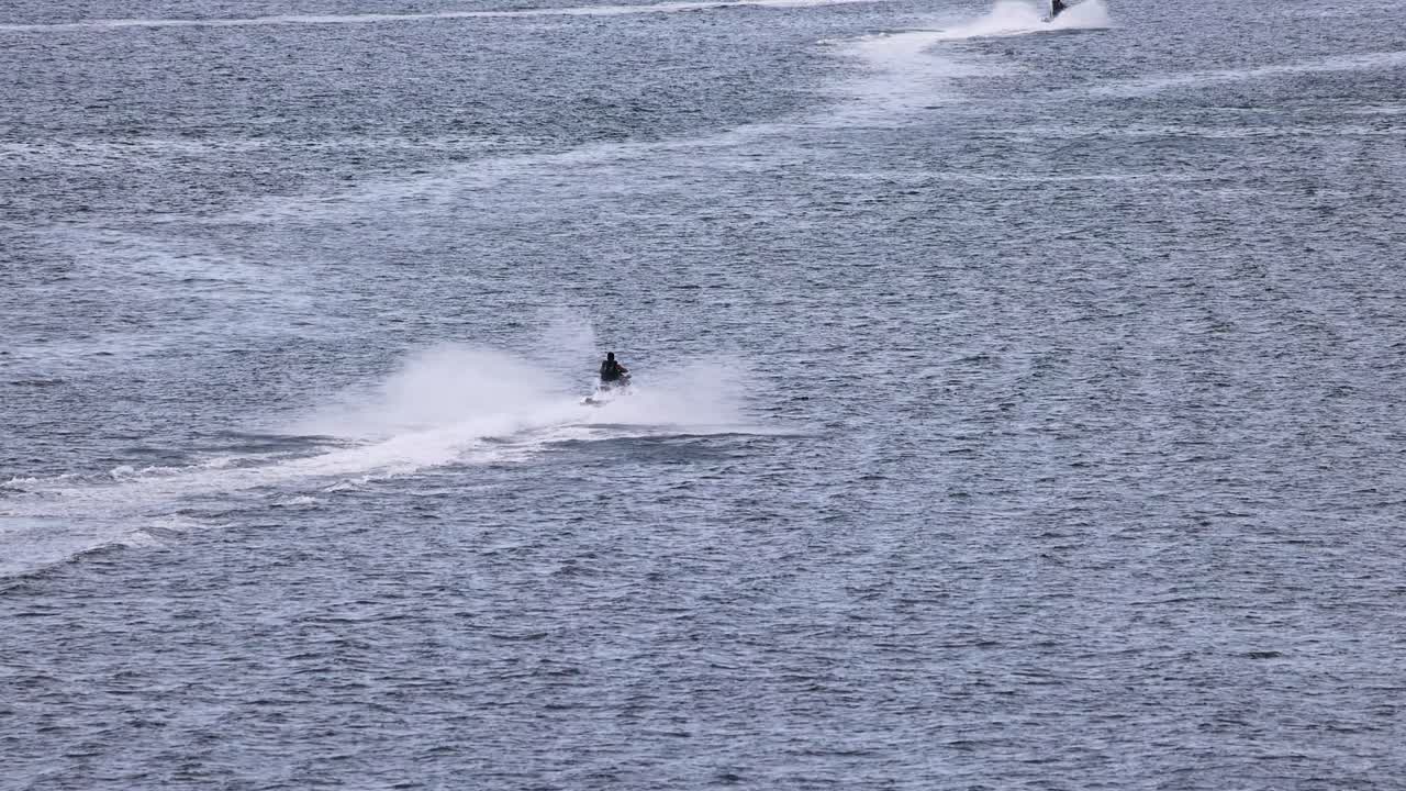 A thrilling jet ski ride across Phuket's ocean, showcasing dynamic movement and vibrant water splashes under clear skies
