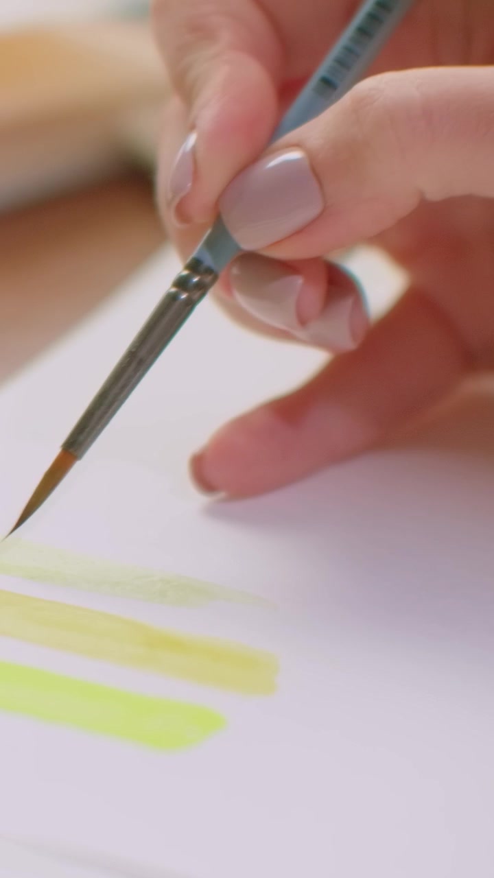 Artista che dipinge campioni di acquerello giallo su carta