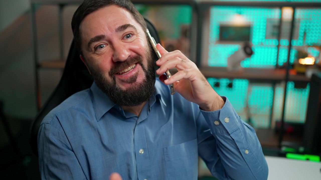 Bearded Man Talking on Smartphone and Gesturing in Office