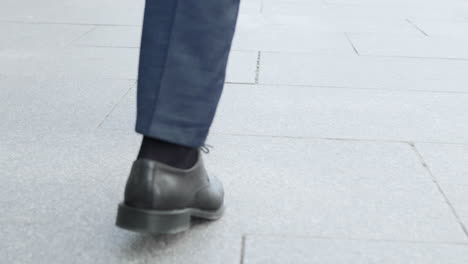 businessman taking walk on street. male executive wearing black shoes outside