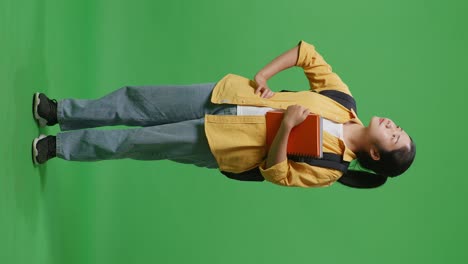 student holding books, green screen