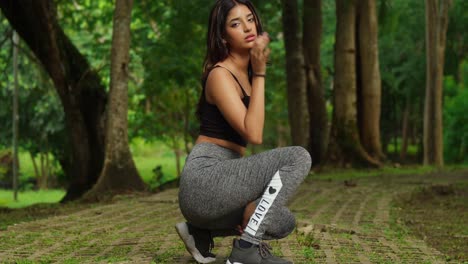 Exercising-in-sports-attire,-a-young-girl-enjoys-the-natural-surroundings-of-the-tropical-park