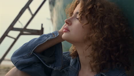 dreamy woman sitting beach gloomy evening leaning on old abandoned boat close up