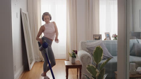 chica adolescente divertida bailando con la aspiradora haciendo tareas limpiando la casa divirtiéndose bailando tonto escuchando música usando auriculares disfrutando de una mañana de fin de semana despreocupada en casa 4k